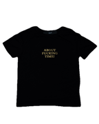 Black t-shirt with gold text on a white background